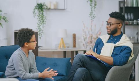 Adult and child sitting and talking image