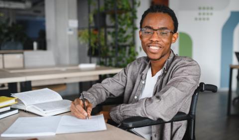 Person reading and writing at a desk image